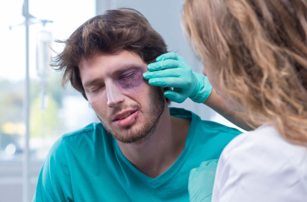 man with a black eye is examined by a female optometrist