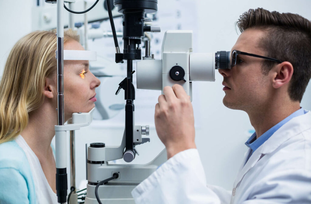 A male optometrist using a slit lamp to examine a woman's right eye