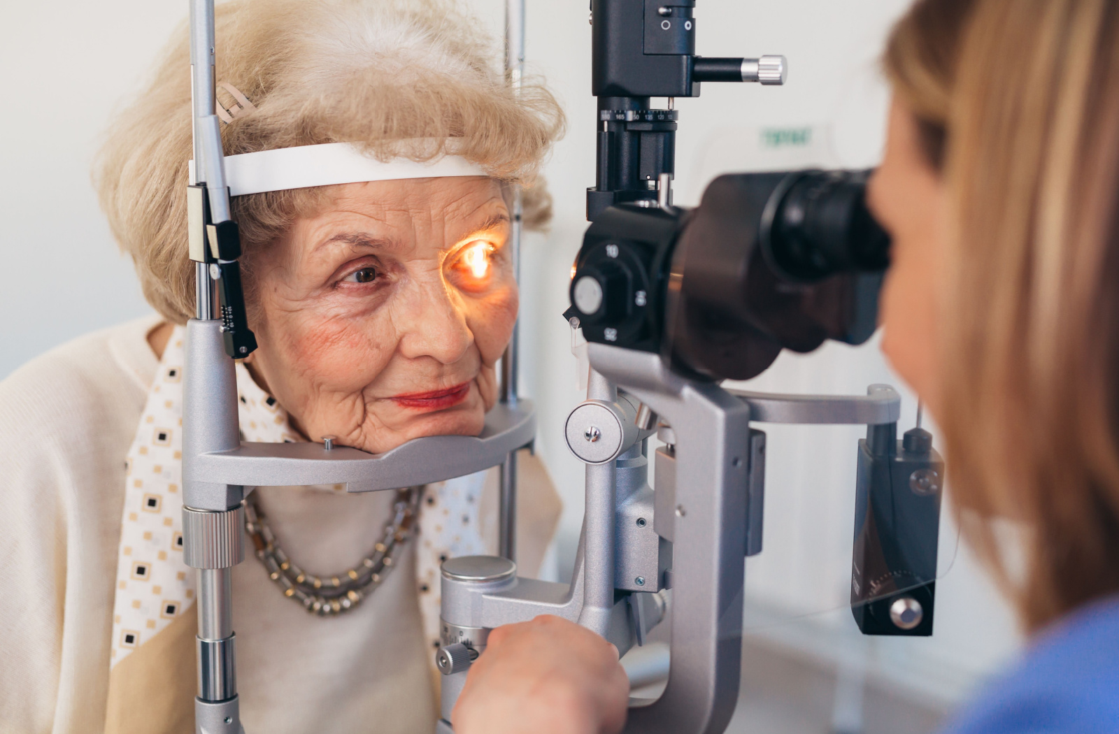 Close-up of an older adult woman undergoing a slit-lamp exam
