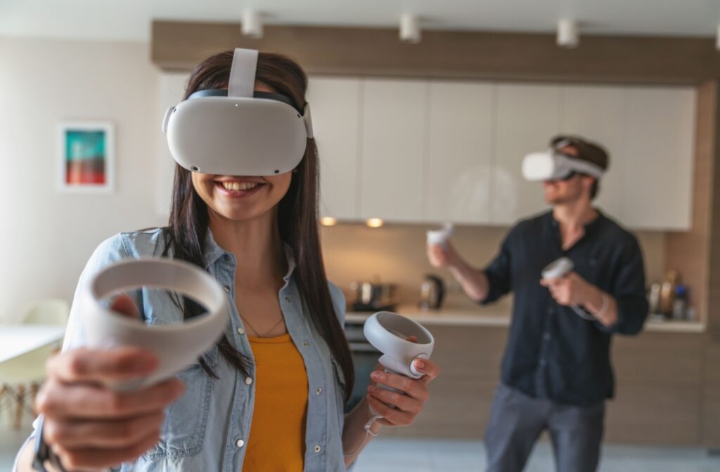 A young couple enjoys playing with their virtual reality headset.