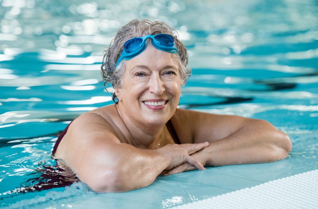 A woman at the edge of a pool wearing prescription goggles instead of contacts